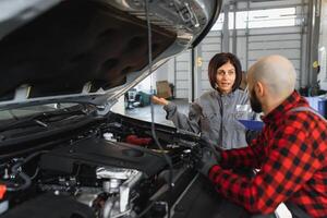 maschio e femmina meccanica Lavorando su auto foto