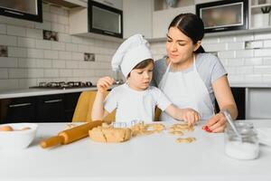 contento madre e poco figlio nel il cucina, contento tempo e solidarieta foto