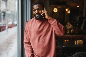 maturo africano americano uomo parlando di Telefono nel bar. foto