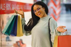 bellissimo africano americano donna Tenere multicolore shopping borse nel un' memorizzare foto