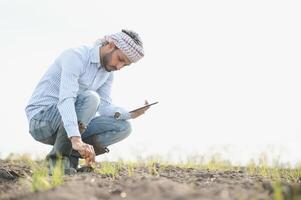 un' giovane indiano contadino ispeziona il suo campo prima semina. foto