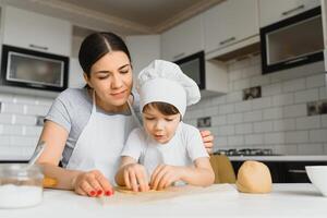 contento madre e poco figlio nel il cucina, contento tempo e solidarieta foto