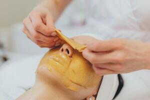 un' ragazza a un' cosmetologo fa cosmetico procedure. alginato maschera foto