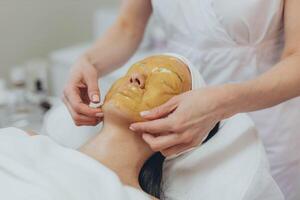 un' ragazza a un' cosmetologo fa cosmetico procedure. alginato maschera foto