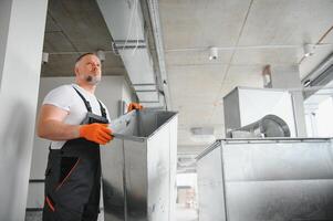 HVAC Servizi - lavoratore installare canalizzato tubo sistema per ventilazione e aria condizionata nel ufficio. foto