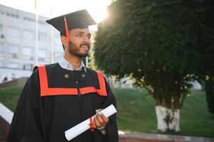 formazione scolastica, la laurea e persone concetto - contento indiano maschio diplomato alunno. foto