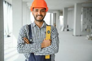 indiano costruzione luogo manager in piedi indossare casco, pensiero a costruzione luogo. ritratto di misto gara Manuale lavoratore o architetto. foto