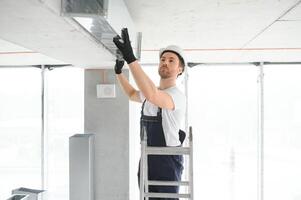 HVAC Servizi - lavoratore installare canalizzato tubo sistema per ventilazione e aria condizionata foto