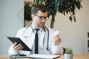 medico Lavorando nel il suo ufficio dando consultazioni in linea al di sopra di il Internet utilizzando il suo il computer portatile computer. telemedicina foto