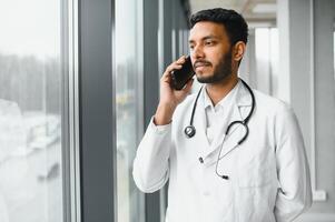 medicinale, assistenza sanitaria e persone concetto - contento maschio medico con stetoscopio e appunti a clinica foto