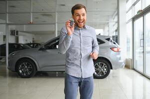 un' uomo sceglie un' nuovo auto per lui stesso passeggiate fra il righe nel un' auto concessionaria foto