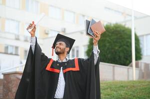 giovane indiano laureato ragazzo Tenere il suo la laurea grado convocazione cerimonia. alunno diplomato in posa. foto