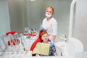 femmina dentista e bambino nel un' dentista ufficio foto