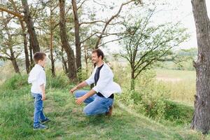 padre e figlio avere divertimento insieme nel natura. padre e figlio giocando. persone avendo divertimento all'aperto. concetto di amichevole famiglia. foto