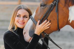 giovane donna fisioterapista assunzione cura un' Marrone cavallo. donna fabbricazione un' trattamento nel il spalla, cresta, fronte, museruola e mento scanalatura. foto