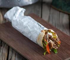 libanese pollo shawarma servito nel un' piatto lato Visualizza su di legno tavolo sfondo foto