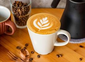 caldo latte macchiato moca arte con caffè fagioli, forchetta, cucchiaio servito nel piatto isolato su di legno tavolo superiore Visualizza di Taiwan cibo foto