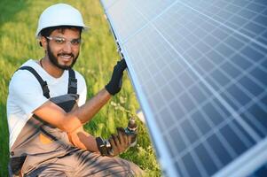 un indiano lavoratore installa solare pannelli. il concetto di rinnovabile energia. foto