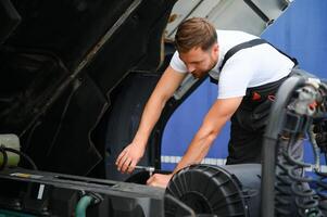 uomo nel uniforme. camion riparazione. auto Malfunzionamento foto