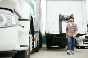 orgoglioso professionale camionista in piedi nel davanti di il suo camion. autotrasporti e mezzi di trasporto tema. foto