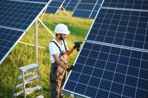 un indiano lavoratore installa solare pannelli. il concetto di rinnovabile energia. foto