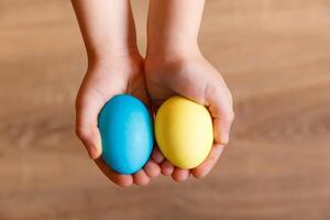 dipingere uova per Pasqua, luminosa Pasqua vacanza, bambini dipingere uova, colorato uova nel un' cestino, colorato uova su un' In piedi, vacanza sfondo foto