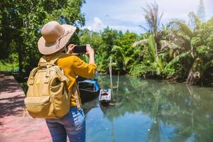 natura di viaggio donna asiatica. viaggiare rilassati. usando il telefono cellulare scatta una foto in barca bellissima natura a tha pom-klong-song-nam. krabi, viaggiare in thailandia.