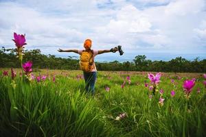 natura di viaggio donna asiatica. viaggiare rilassati. fotografia campo di fiori di cetriolo sessilis. foto