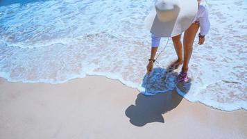 le donne asiatiche viaggiano nella natura. viaggiare rilassati. gioca con l'acqua di mare sulla spiaggia. in estate. Tailandia foto