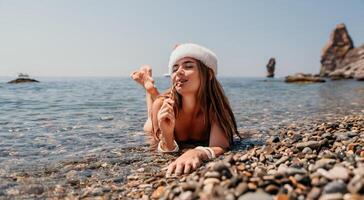 donna viaggio mare. contento turista godere assunzione immagine su il spiaggia per ricordi. donna viaggiatore nel Santa cappello sembra a telecamera su il mare baia, condivisione viaggio avventura viaggio foto