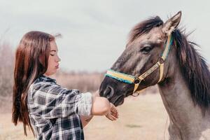 giovane contento donna con sua pony cavallo nel sera tramonto luce. all'aperto fotografia con moda modello ragazza. stile di vita umore. concetto di all'aperto cavalcare, gli sport e ricreazione. foto