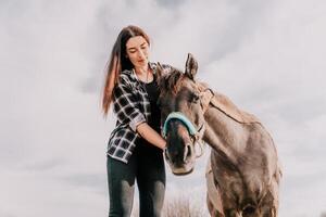 giovane contento donna con sua pony cavallo nel sera tramonto luce. all'aperto fotografia con moda modello ragazza. stile di vita umore. concetto di all'aperto cavalcare, gli sport e ricreazione. foto