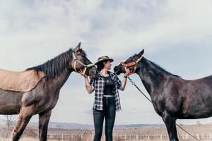 giovane contento donna nel cappello con sua cavallo nel sera tramonto luce. all'aperto fotografia con moda modello ragazza. stile di vita umore. concetto di all'aperto cavalcare, gli sport e ricreazione. foto