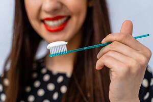 donna con grande denti Tenere spazzolino nel davanti di telecamera. sfocato sfondo. foto