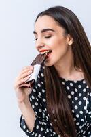 allegro donna mangiare cioccolato. ritagliata foto. avvicinamento. nero cioccolato con noccioline. foto