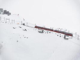 aereo Visualizza di rosso treno nel nevoso Zermatt sciare ricorrere, Svizzera foto