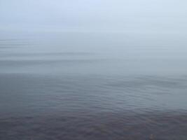 mattina nebbia al di sopra di il lago, liscio acqua, silenzio, bianca e grigio pendenza sfondo foto