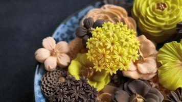 tailandese dolce nel vario fiore sagomato, caldo colore tono, arancia, cioccolato e Mango gusto, sam padella nata tradizionale tailandese fatto a mano merenda nel buio sfondo, reale famoso tailandese dolci foto