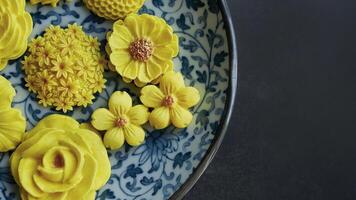 tailandese dolce nel vario fiore sagomato, caldo colore tono, giallo Mango gusto nel antico modello piatto, sam padella nata tradizionale tailandese fatto a mano merenda nel buio sfondo foto