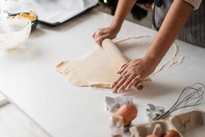 donna sorridente in cucina a cuocere i biscotti di natale foto