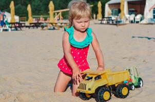contento bambino piccolo bambino giocando su il spiaggia con giocattolo auto.estate vacanza viaggio concetto. copia spazio. foto