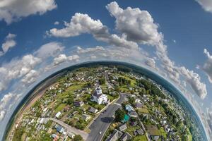 aereo Visualizza a partire dal alto altitudine minuscolo pianeta nel cielo con nuvole prospiciente vecchio cittadina, urbano sviluppo, edifici e incrocio stradale. trasformazione di sferico 360 panorama nel astratto aereo Visualizza. foto