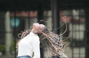 un' giovane donna con il suo acconciatura e il atmosfera di vivente nel il Comunità. foto