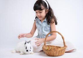 sorridente poco ragazza e con loro Amati soffice coniglio, in mostra il bellezza di amicizia fra gli esseri umani e animali foto