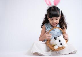 sorridente poco ragazza e con loro Amati soffice coniglio, in mostra il bellezza di amicizia fra gli esseri umani e animali foto