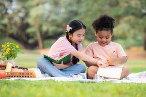 contento famiglia godendo un' picnic nel il parco, bambini siamo avendo divertimento disegno su carta. foto