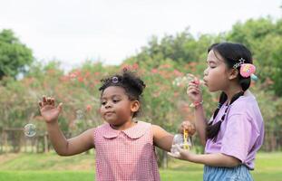 ragazze nel il parco con soffiaggio aria bolla, circondato di verdura e natura foto