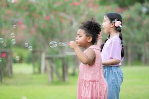 ragazze nel il parco con soffiaggio aria bolla, circondato di verdura e natura foto