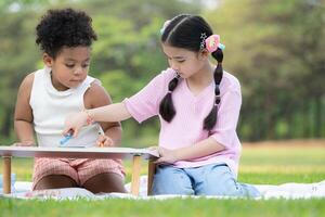 contento famiglia godendo un' picnic nel il parco, bambini siamo avendo divertimento disegno su carta posto su il tavolo. foto