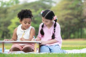 contento famiglia godendo un' picnic nel il parco, bambini siamo avendo divertimento disegno su carta posto su il tavolo. foto